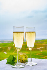 Tasting of french sparkling white wine with bubbles champagne on outdoor terrace with view on grand cru Champagne vineyards in Cramant, near Epernay, France