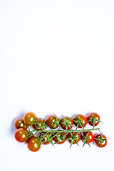 Vine of fresh ripe sweet cherry tomatoes ready to eat on white background