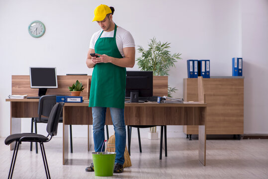 Young male contractor cleaning the office