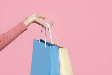 Shopper and shopaholic, active spare time. Hand of african american woman holding blue and yellow...