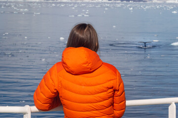 Woman on whale watching. Whale showing its tail from the water in Antarctica © Anton