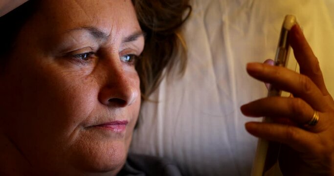 Woman staring at smartphone screen at night