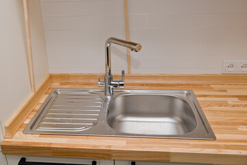 Modern faucet with steel sink. Kitchen interior.