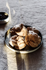 Homemade sweet chocolate meringue cookies on plate over greige linen tablecloth. Delicious and light holiday dessert