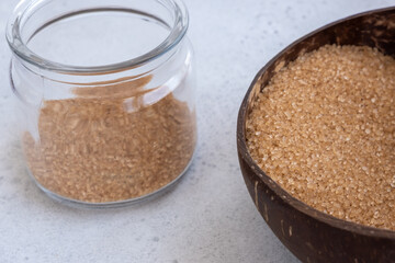 brown sugar in a coconut bowl. sugar against an out of focus wood background - copy space