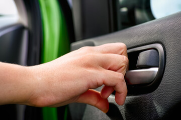 Person hand closing car interior door.
