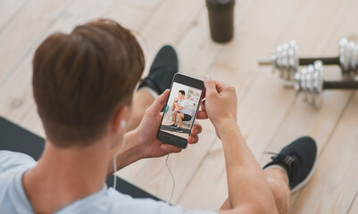 Stay home workout concept. Young guy following sports blogger on web, watching online workout on...