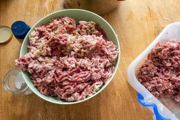Portion of Minced Meat on an old wooden table. The preparation of the filling for dumplings.