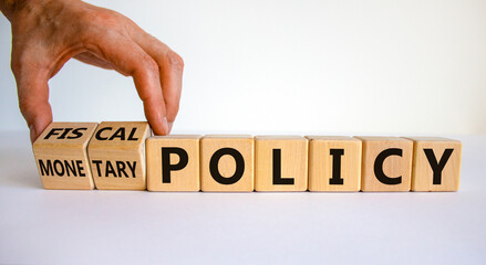 Fiscal or monetary policy symbol. Hand turns cubes and changes words 'fiscal policy' to 'monetary policy'. Beautiful white background. Business and fiscal or monetary policy concept. Copy space.