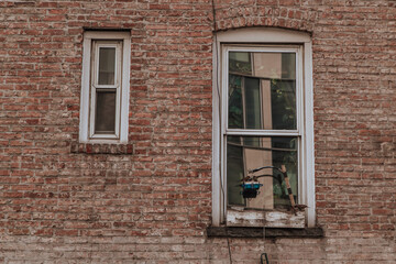 Fototapeta na wymiar Sparrow birds on the window of an old brick house, eating grain from a feeder