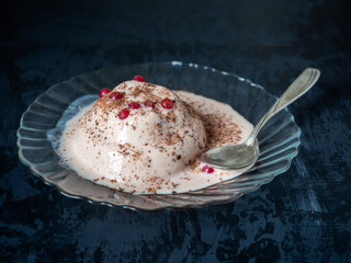 Slightly thawed ice cream with chocolate on a glass plate with red currant berries