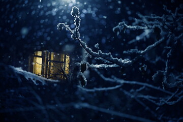 The window is lit against the background of falling snow
