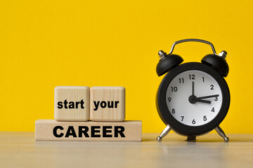 START YOUR CARRER text written on cubes, alarm clock on a yellow background. The concept of world...