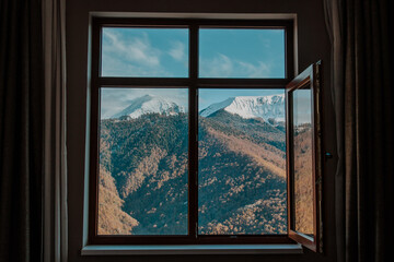 Fototapeta na wymiar Rosa Khutor. Stunning view from the window of the house to the winter mountains and forest