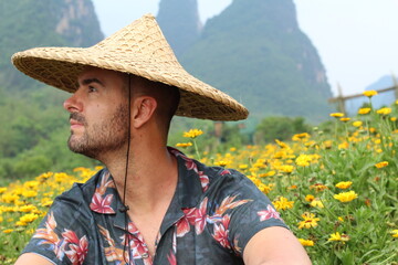 Fototapeta premium Caucasian man in agricultural Asian flower field