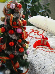 Decorated Christmas tree on the front blurred background. Christmas and New Year decorations lie on the bed, prepared to decorate the Christmas tree on Christmas Eve.