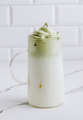 Dalgona Matcha Latte, a creamy whipped matcha, on light background. Matcha green tea.