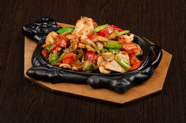 chicken stew with vegetables in a dish on a wooden background