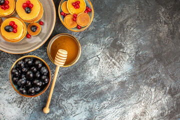 Fototapeta na wymiar Family breakfast fruit pancakes served with honey and black cherry