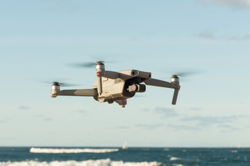 Fototapeta na wymiar Drone flying. Blue sky and ocean background.