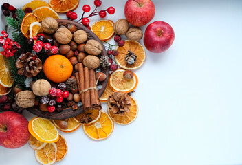 Fototapeta na wymiar Christmas nature decor with nuts, cinnamon, cones, berries, orange citrus. Christmas and new year festive concept. traditional winter holiday composition with nature decor. flat lay