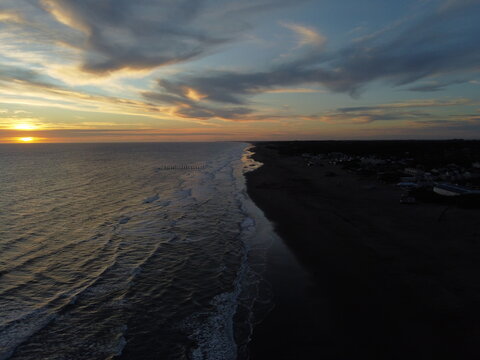 Sunset on Atlantic ocean Argentine coasts, brown sand and blue waves, picture with a drone. Monte Hermoso, Argentina