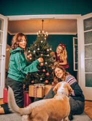 Group of friends with dog enjoying Christmas eve. Happy New Year and Merry Christmas.