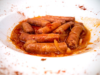 Fried spanish chorizo white plate closeup view