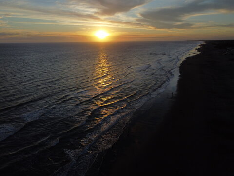 Sunset on Atlantic ocean Argentine coasts, brown sand and blue waves, picture with a drone. Monte Hermoso, Argentina