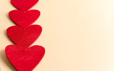 Red hearts close up lie on beige background, valentine background concept with copy space and flat lay, selective focus