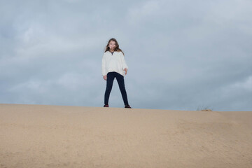 cute young girl running in the dunes in autumn