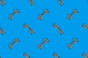 Background on the theme of glasses for vision. Glasses seamless pattern on a blue background.