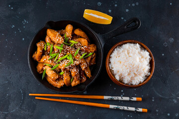  Teriyaki chicken breast in frying pan with rice and sesame seeds top view, traditional asian food