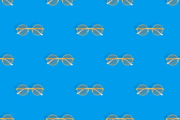 Background on the theme of glasses for vision. Glasses seamless pattern on a blue background.