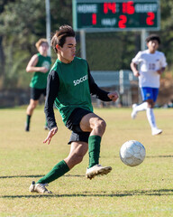 Young athletic boy competing in a soccer game