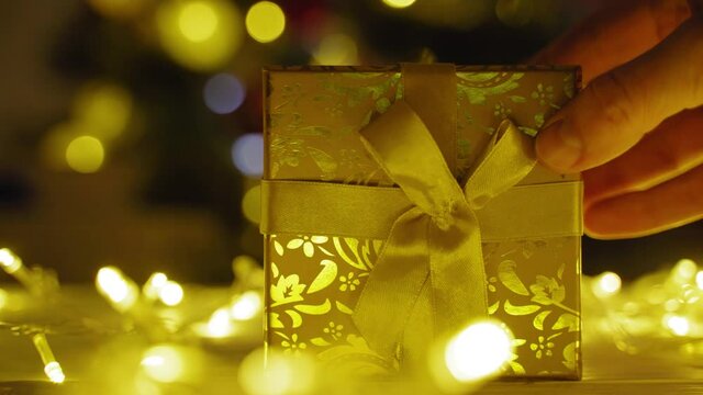 Christmas present on table against the background of the Christmas tree