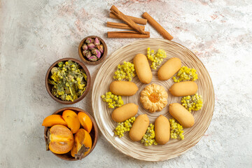 a plate of cookies and cinnamon sticks and dry lavender and yellow flower and a bowl of palm