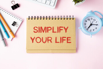 Simplify Your Life Text written on notebook page, red pencil on the right. Motivational Concept...