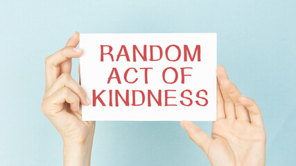 RANDOM ACT OF KINDNESS message on a yellow card hold by a business woman, business concept image...