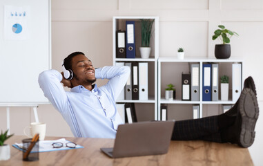 Obraz premium Peaceful black manager listening to music in his office