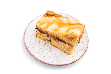 Honey cake with milk cream, caramel, almonds isolated on a white background. Side view.