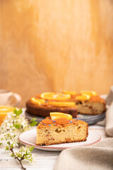 Orange cake and a cup of coffee on a white wooden background. Side view, selective focus, copy space.