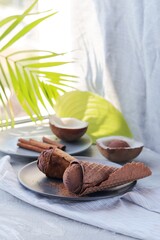 Homemade chocolate ice cream in waffle cones, coconuts on a light table, top view, home cooking products, healthy food