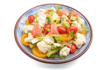 Vegetarian salad of cauliflower cabbage, kiwi, tomatoes, microgreen sprouts isolated on white background. Side view.