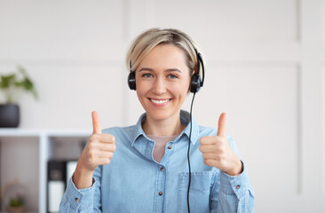 Remote education, work, business. Happy young woman in headset looking at camera and showing thumbs...