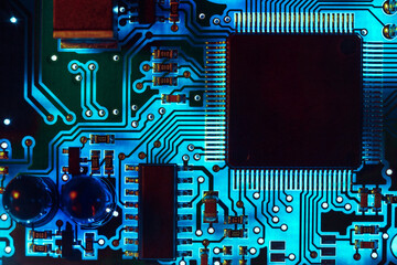 Close-up of a modern blue printed circuit board (PCB) with stripes of conductors between a...