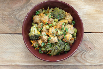 Soy goulash, protein food with stewed vegetables: pea, broccoli, carrot and spices, healthy vegan meal - a source of proteins, closeup, copy space
