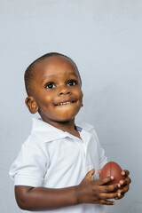 Cute toddler preschool age little boy playing with a football toy