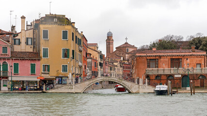 Fototapeta na wymiar Arch Bridge Over Canal at Rainy Winter Day in Venice Italy