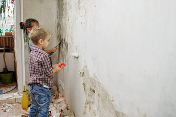 Obraz na płótnie Canvas Father with kid repairing room together and painting the wall together